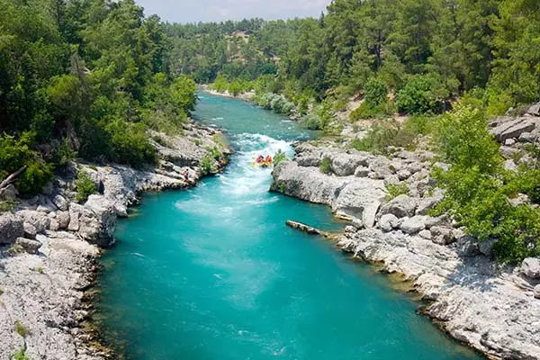 Rafters on a river with rocky banks